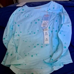 Size 5T long-sleeved T shirt. Mint background with green stars all over.